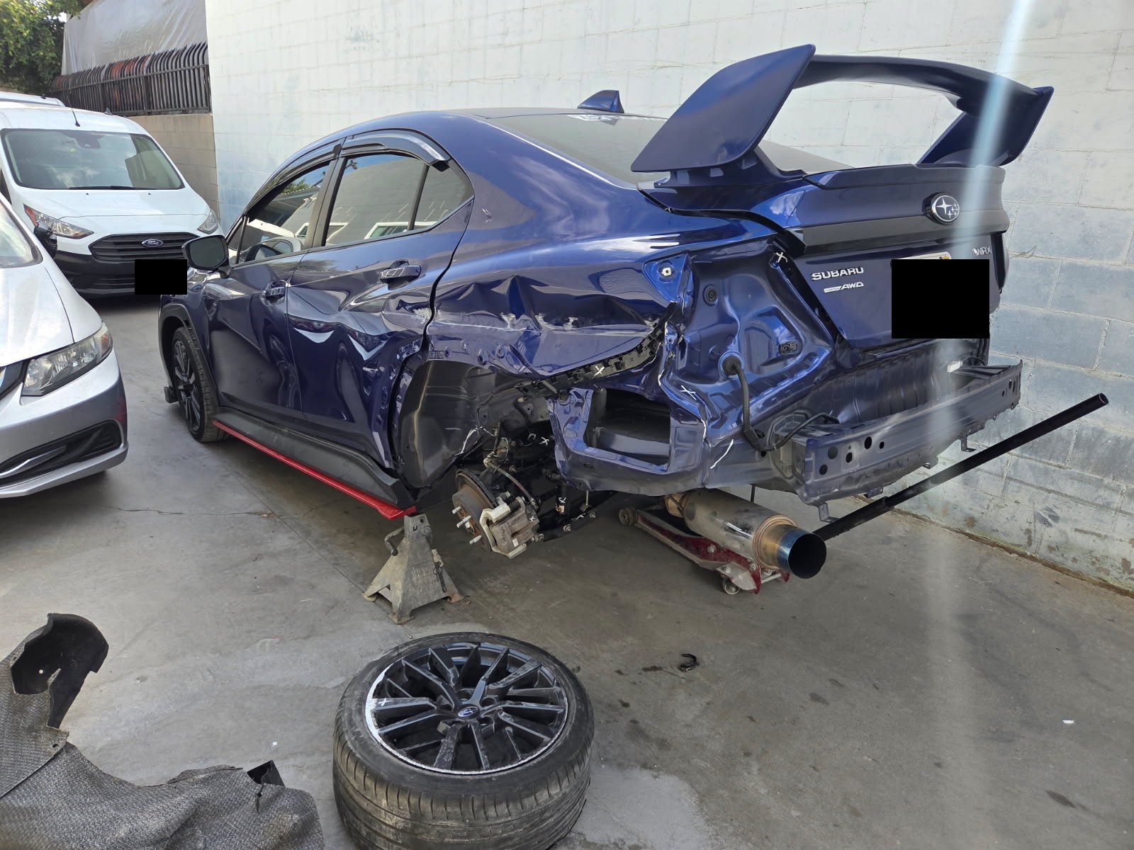 Subaru azul con daño trasero antes de la reparación
