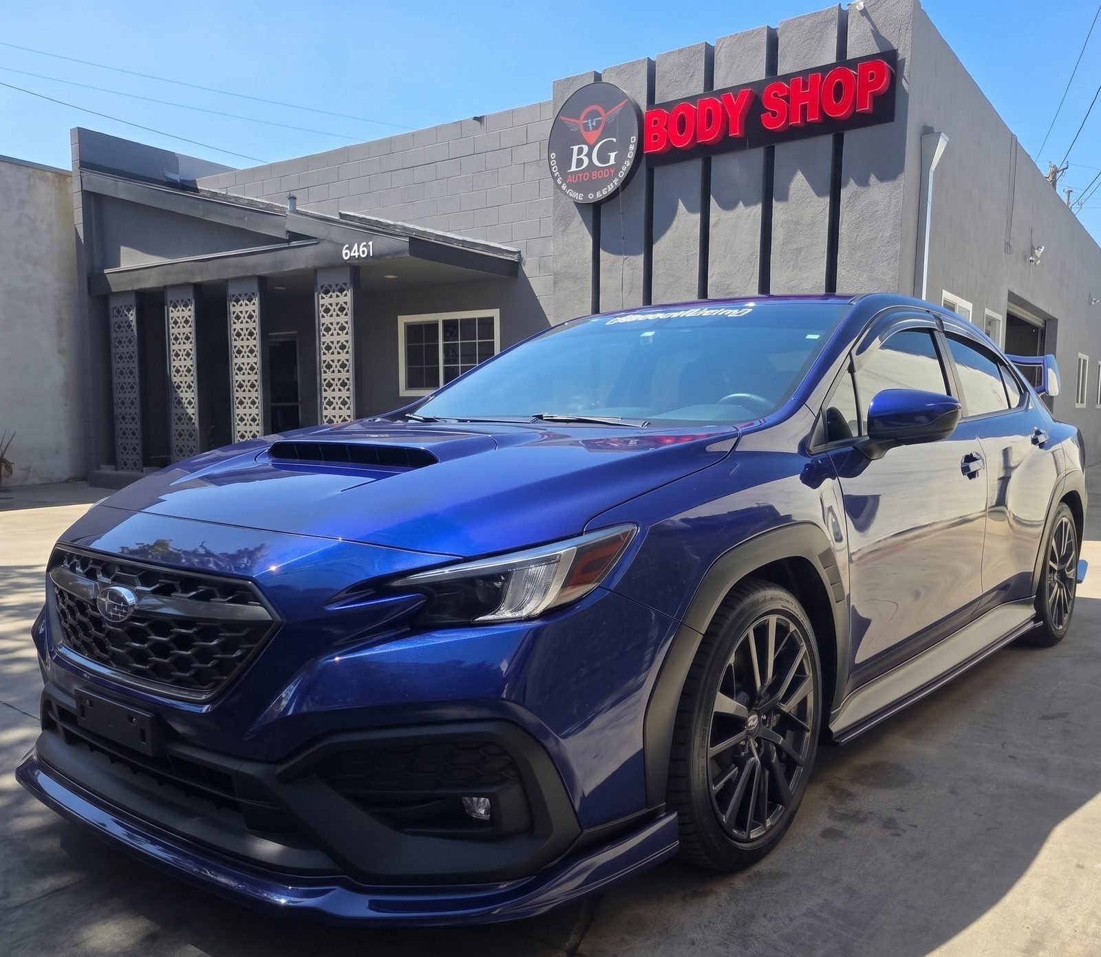 BG Auto Body auto body shop exterior in Bell Gardens with a blue Subaru in front